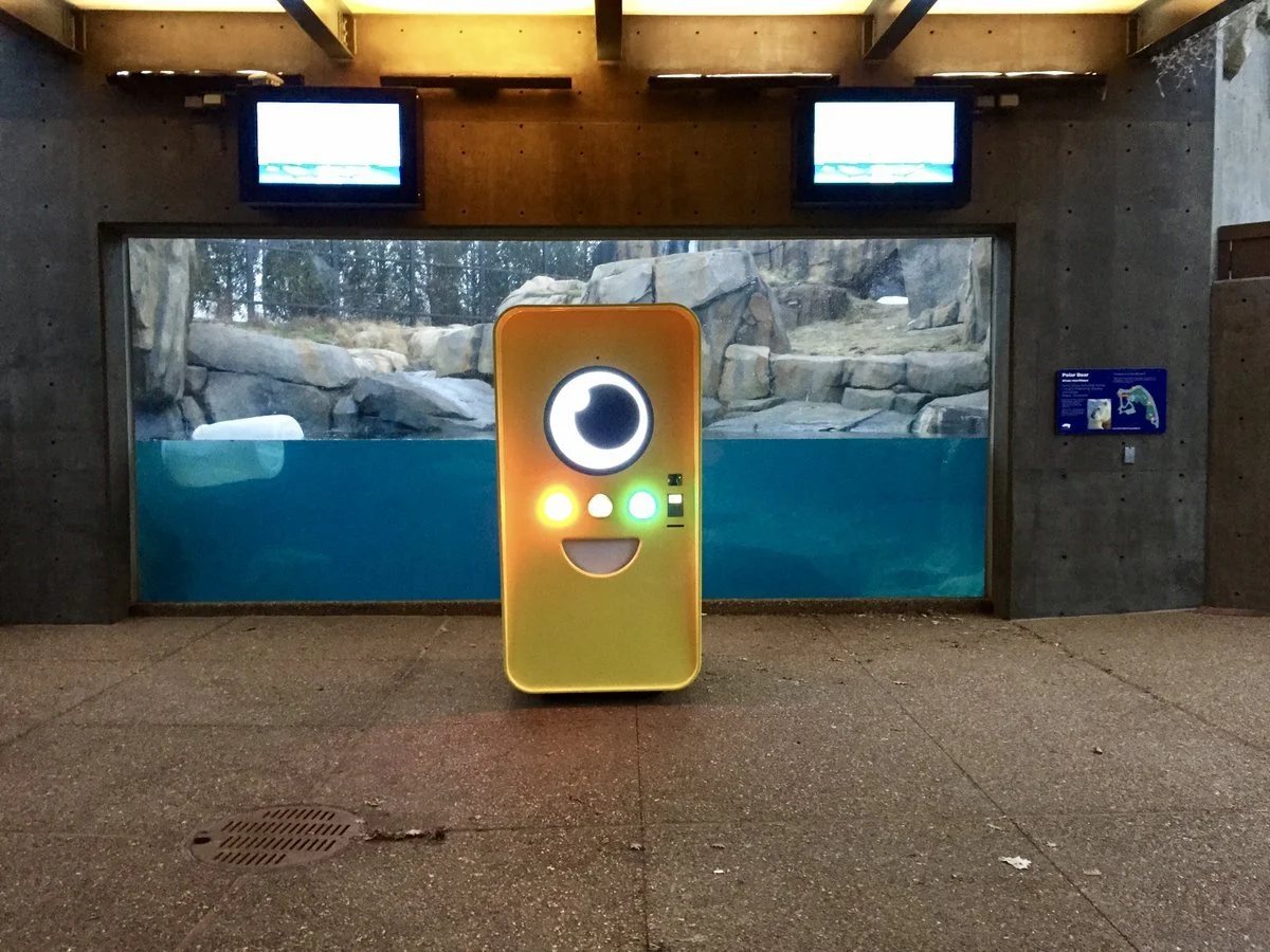 Orange-yellow Snapbot vending machine in front of a polar bear underwater viewing tank with a Polar Bear sign.
